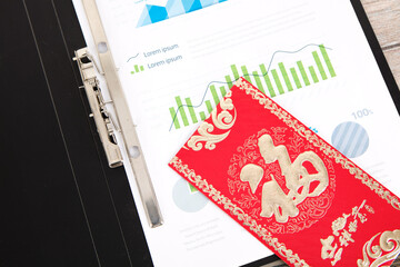 Financial chart in the folder and red envelope on it