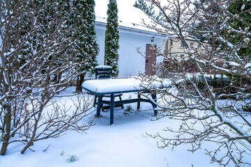 Table and chair in the winter garden near the house. Winter mood concept