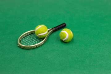 Tennis racket and ball are on green background