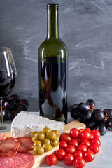 meat platter and wine. a variety of hams, olives, tomatoes,grapes and brie cheese.(Antipasto or tapas)