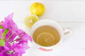 mix honey lemon herbal hot healthy drinks for sore throat with lemon slice and purple flowers...