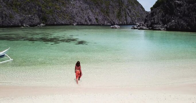 Aerial view of woman with sarong in a beautiful turquoise lagoon, El Nido, Philippines