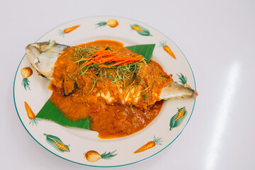 Top view of spicy and hot king fish curry with herb and chili on wooden table, Thai food made from coconut milk and egg pant whit herbs, Fish curry