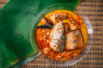 Top view of spicy and hot king fish curry with herb and chili on wooden table, Thai food made from coconut milk and egg pant whit herbs, Fish curry