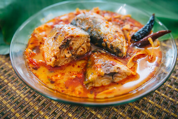 Top view of spicy and hot king fish curry with herb and chili on wooden table, Thai food made from coconut milk and egg pant whit herbs, Fish curry