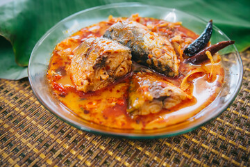 Top view of spicy and hot king fish curry with herb and chili on wooden table, Thai food made from coconut milk and egg pant whit herbs, Fish curry
