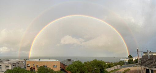 Double rainbow panorama over O'Sullivan Beach Australian coast. 4 pots of gold.