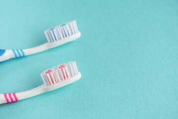 Two clean toothbrushes on a blue background. Copy Space