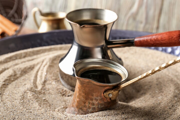 Turkish coffee cooked in sand on table