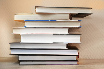 On the wooden surface is a stack of books stacked on top of each other. The concept of education and hobby