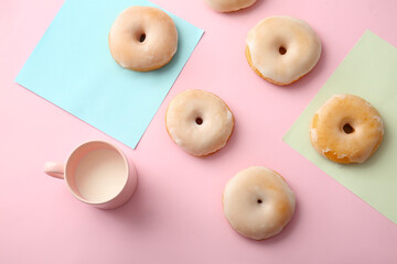 Tasty donuts and cup of milk on color background