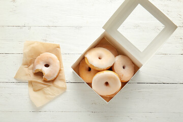 Box with tasty donuts on wooden background