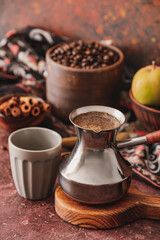 Cezve with coffee and cup on table