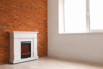 Modern fireplace near brick wall in room