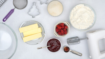 Christmas shortbread cookies with raspberry preserves recipe. Ingredients for baking needs close up on kitchen table, view from above