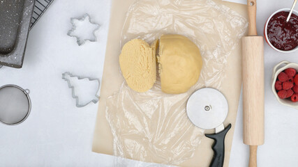 Cookie dough close up on kitchen table. Shortbread cookies with raspberry jam close up baking process.