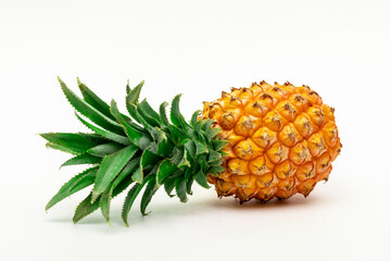 Whole ripe pineapple fruit, lying horizontally, on a white background.