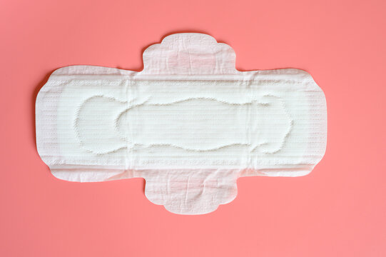 pure empty women's disposable menstrual sanitary pad or napkin for normal abundance of secretions on pink background