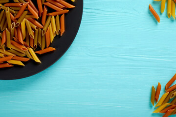 Raw pasta on a black plate, top view, copy space
