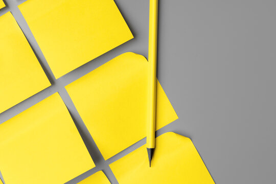 Yellow adhesive notes on gray background close up