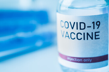 A single bottle vial of Covid-19 vaccine. Medical concept vaccination hypodermic injection...
