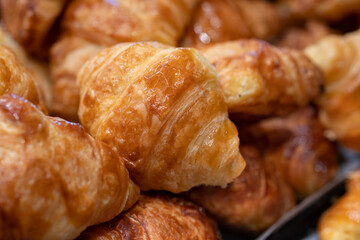 Fresh butter croissants with chocolate sprinkles for sale at bakery store