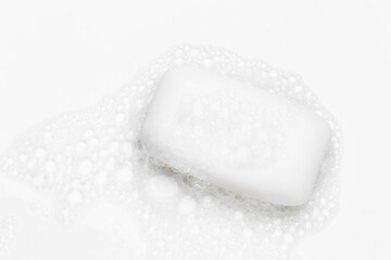 Soap bar and foam on white background