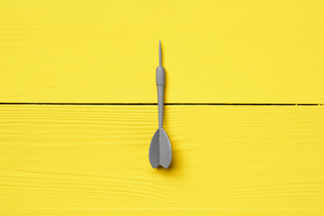 Gray dart arrow on yellow background copy space