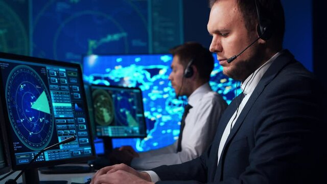 Workplace of the air traffic controllers in the control tower. Team of aircraft control officers works using radar, computer navigation and digital maps. Aviation concept.