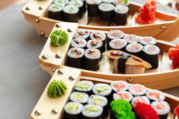 Set of maki sushi on wooden boat tray