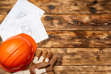 Hardhat, gloves and blueprints of a builder