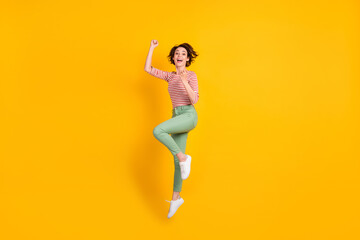 Fototapeta na wymiar Full length body size view of charming cheerful girl jumping rejoicing having fun isolated over bright yellow color background