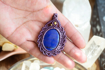 Lapis lazuli gemstone macrame pendant on natural background