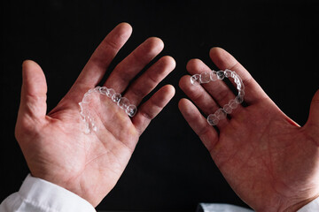 Doctor hands holding a transparent dental aligner