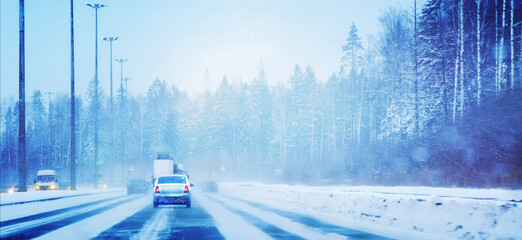 A winter highway with cars in the forest