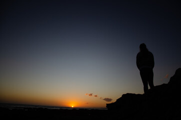 silhouette of a person on a rock
