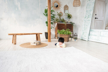 広い部屋で寝っ転がる日本人の赤ちゃん　コピースペースあり 広角