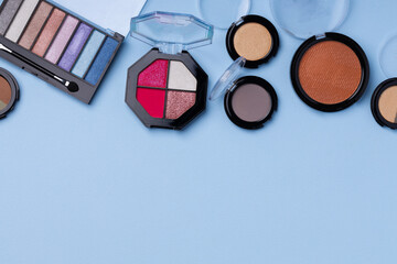 Set of eyeshadows on blue background close up