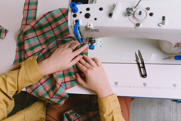 Top view of woman working with sewing machine in her workshop