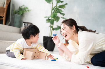 きれいな新築の様な広い部屋で美人なママと家族団らんの幸せな若いファミリー 下にコピースペースあり Wall Mural Kapinon
