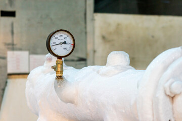 Metal pipes covered with a layer of frost. Industrial refrigerating machine.