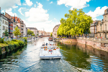 Scenic view of a tourist boat on a river canal in the historical city of Strasbourg, France on a...