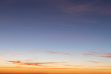 Heaven at early morning with copy space. Sunset, sunrise backdrop.Predawn clear sky with orange horizon and blue atmosphere. Smooth orange blue gradient of dawn sky.
