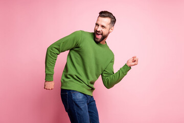 Portrait of attractive cheerful mature guy celebrating having fun dancing isolated over pink pastel...