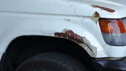 Scratch and peeling paint at the front car fender