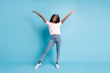Fototapeta na wymiar Full length photo of adorable pretty afro woman wear pink t-shirt denim hands arms up isolated blue color background