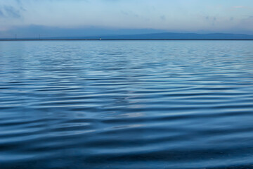 blue sky and water. a surface of a water or river that looks like a satin fabric texture