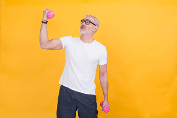 attractive mature man doing sports and showing muscle with dumbbells