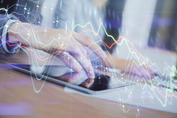 Double exposure of forex graph drawing and man and woman working together holding and using a mobile device. Trade concept.