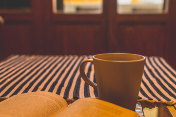 Cup of coffee and book in front of the window